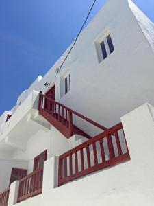 a white building with red stairs on it at Casal Paleologos Villa in Mikonos