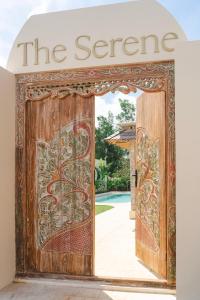 Uluwatu Lagoons - Retreat and Villas في أُلُواتو: مدخل لمبنى فيه باب خشبي كبير