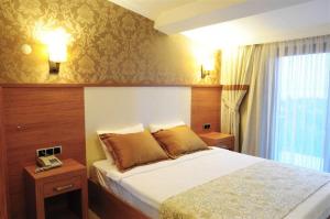A bed or beds in a room at Assos Park Hotel