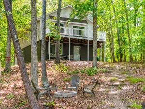 a house with two chairs in the woods at Waterfront home with dock on Kerr Lake! in Clarksville