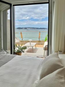 a bedroom with a bed and a view of the ocean at La terraza da Braña in Villanueva de Arosa