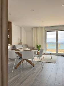 a dining room with a table and chairs and the ocean at La terraza da Braña in Villanueva de Arosa