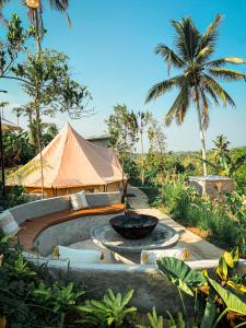 a garden with a fire pit and a tent at KA MANIcamp in Angsri