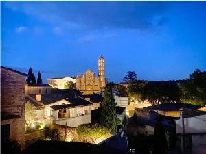 - une vue sur une ville la nuit avec une tour d'horloge dans l'établissement Chambre d'Hôte vue exepitonnelle, à Uzès