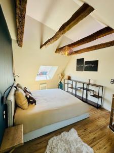 a bedroom with a large bed and wooden floors at À l'Ombre du Clocher in Laguiole