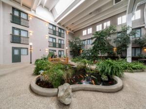 a lobby with a koi pond in the middle of a building at Heritage Inn Hotel & Convention Centre - Brooks in Brooks