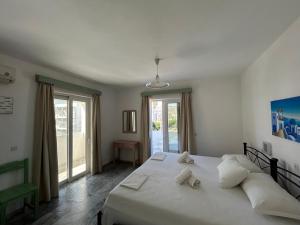a bedroom with a large white bed and a window at Kaloxenia in Kardamaina +42 photos