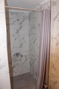 a bathroom with a shower with a shower curtain at Seaside Dream Kallithea in Kallithea Halkidikis +49 photos