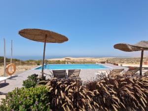 una piscina con ombrelloni e sedie e una piscina di Timlalin Dome a Tamri Altre 29 foto