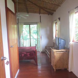 a living room with a tv on a wooden table at Hotel Lara's Planet in El Castillo de La Concepción
