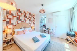 a bedroom with a bed with two towels on it at Tulipe Roanne centre-ville - Parking & Clim in Roanne