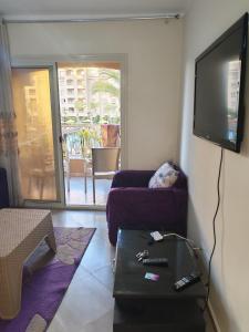 ein Wohnzimmer mit Couch und Flachbildfernseher in der Unterkunft منتجع اكوا ڤيو الساحل الشمالي in El Qasaba esh Sharqīya