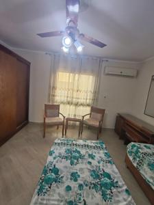 ein Schlafzimmer mit zwei Betten und einem Deckenventilator in der Unterkunft منتجع اكوا ڤيو الساحل الشمالي in El Qasaba esh Sharqīya