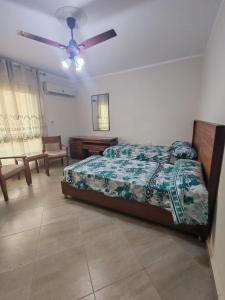 ein Schlafzimmer mit einem Bett und einem Deckenventilator in der Unterkunft منتجع اكوا ڤيو الساحل الشمالي in El Qasaba esh Sharqīya