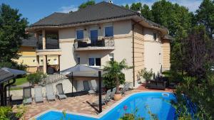 una casa con piscina frente a ella en Villa Riccardo & Pool, en Siófok