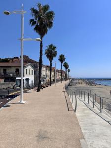 a beach with palm trees and a street light at Casa al Prino in Imperia