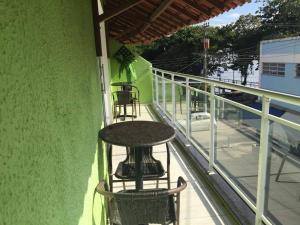 a balcony with a table and chairs on a building at pousada do rei in Pedra de Guaratiba