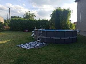 a pool in a yard with a ladder next to it at Apartment 3 floor in Vratimov