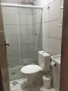 a small bathroom with a toilet and a shower at pousada do rei in Pedra de Guaratiba