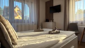 a bedroom with a large white bed with a window at Rodzinna Ostoja in Zakopane