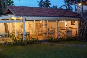 a house with a patio with tables and chairs at Exotica Bungalows in Hikkaduwa