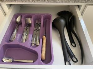 a purple tray with utensils in a drawer at Bayt Hassan A13 - Superb 2 bedrooms in Hurghada
