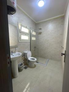 a bathroom with a toilet and a sink and a shower at Bayt Hassan A13 - Superb 2 bedrooms in Hurghada +16 photos