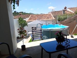 a patio with a swimming pool and a table and a table sidx sidx at Alojamiento Rural Los Jarritos in Galaroza