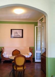 a living room with a table and chairs and a couch at Locanda Miranda in Tellaro