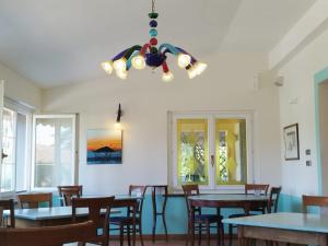 a dining room with tables and chairs and a chandelier at Locanda Miranda in Tellaro