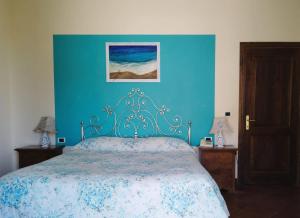 a bedroom with a bed with a blue wall at Locanda Miranda in Tellaro