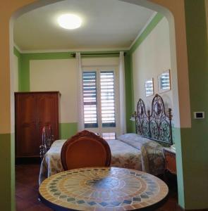 a bedroom with a bed and a table in a room at Locanda Miranda in Tellaro