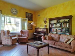 a living room with a couch and chairs and a piano at Locanda Miranda in Tellaro