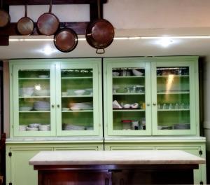 a kitchen with green cabinets and pots and pans at Locanda Miranda in Tellaro