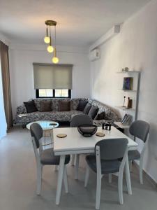 a living room with a table and chairs and a couch at Suar Apartment in Ksamil