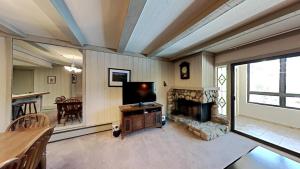 a living room with a television and a fireplace at Beautiful 2 BR Condo with Mountain View! in Mammoth Lakes
