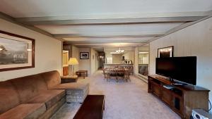 a living room with a couch and a flat screen tv at Beautiful 2 BR Condo with Mountain View! in Mammoth Lakes