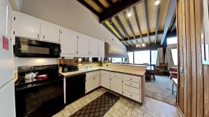 a kitchen with white cabinets and a black appliances at Cozy 4-Bedroom Home with Pool and Mountain View! in Mammoth Lakes