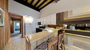 a kitchen with a wooden counter and chairs in it at Cozy 4-Bedroom Home with Pool and Mountain View! in Mammoth Lakes