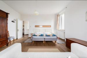 a white bedroom with a bed and a couch at agriturismo villa marani in Villa