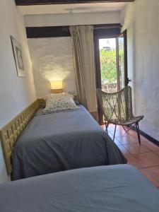 ein Schlafzimmer mit einem Bett und einem Stuhl und einem Fenster in der Unterkunft 8i Ocean Front Playa 4 in San Bartolomé de Tirajana