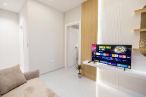 a living room with a flat screen tv on a wall at Nova Studio Drymades in Dhërmi +8 photos