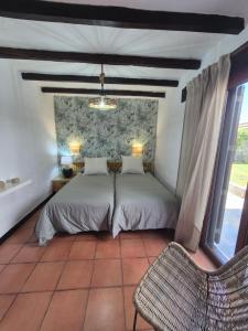 ein Schlafzimmer mit einem Bett und einem Stuhl in der Unterkunft 8i Ocean Front Playa 4 in San Bartolomé de Tirajana