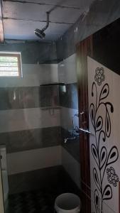 a bathroom with a shower with a toilet in it at Saketa Homestay in Linganamakki
