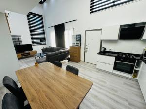 a living room with a wooden table and a kitchen at Private Holiday Home in Kérynia