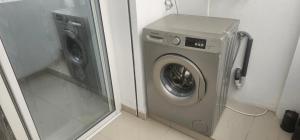 a washing machine in a corner of a bathroom at Apartment in recent residence in Monastir