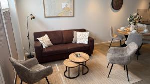 a living room with a couch and chairs and a table at De Kajuit in Westkapelle