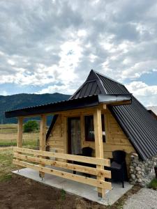 a log cabin with a black roof and a porch at Vekova koliba in Žabljak
