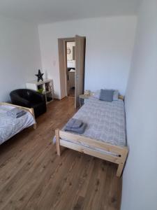 a bedroom with a bed and a living room at GABE Vendègház in Gyöngyöstarján