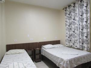 a bedroom with two beds and a curtain at Las Vegas Hotel in Sao Paulo +24 photos